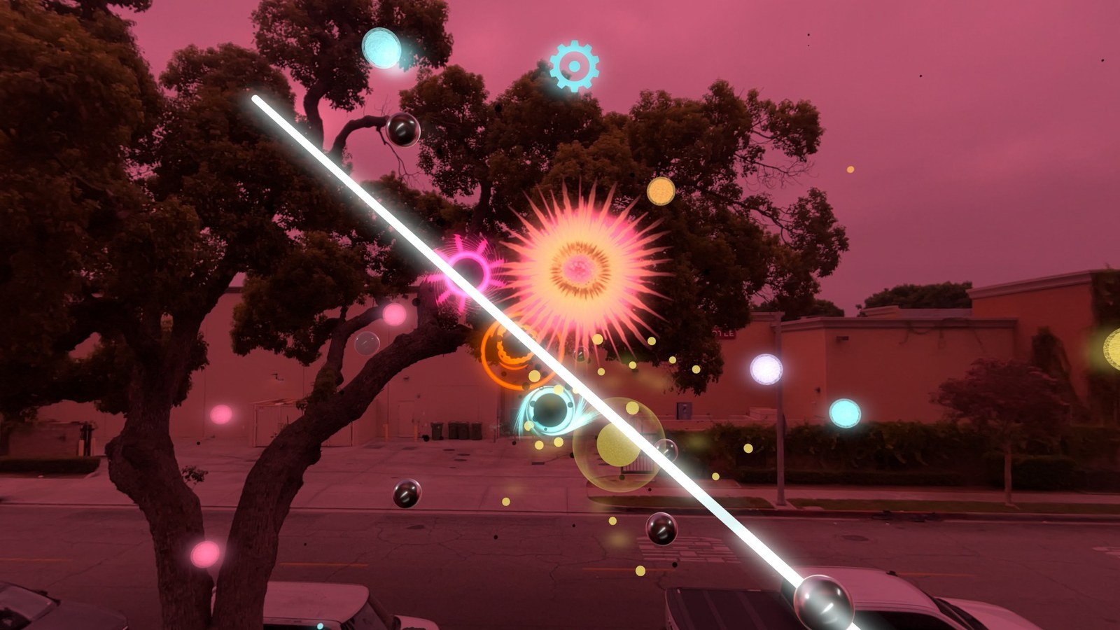 A bright diagonal laser crosses a pink-tinted mixed-reality view filled with colored spheres and an orange starburst.