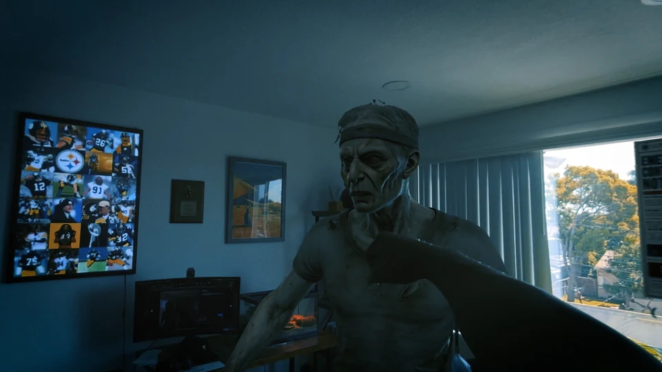 A first-person arm extends toward an infected character during a fight inside a real room.
