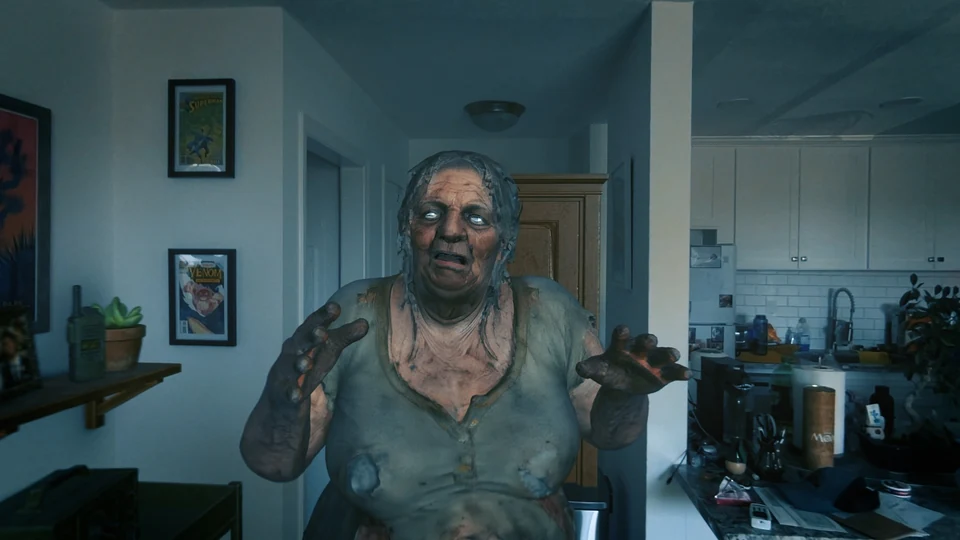An older infected woman reaches toward the viewer, standing in front of a real kitchen and hallway.